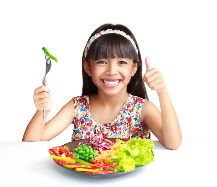 kid giving the thumbs up over a plate of fresh vegetables