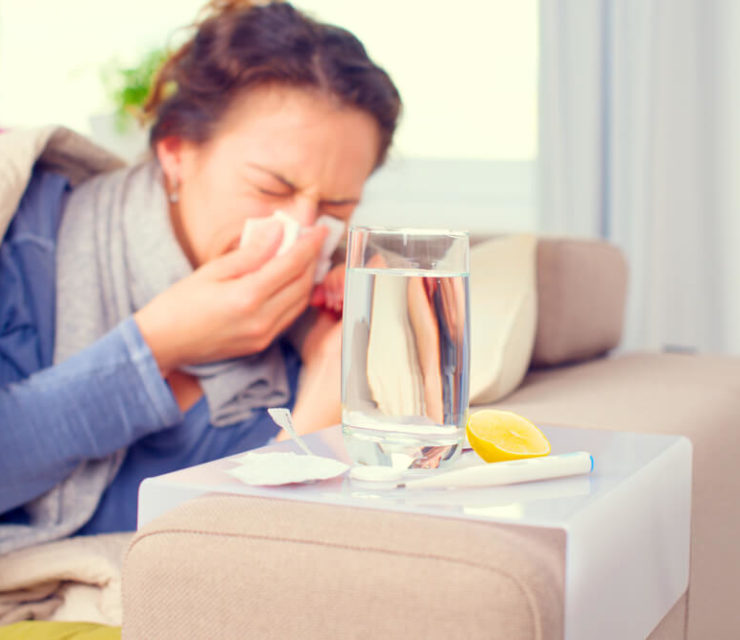 Sick Woman Sneezing into Tissue