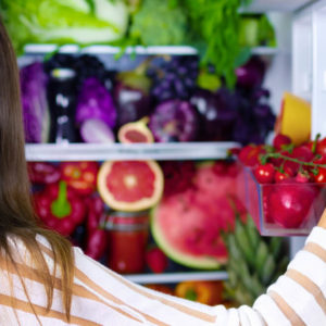 Vegan woman choosing healthy antioxidant colorful veggies, raw juice and fruits