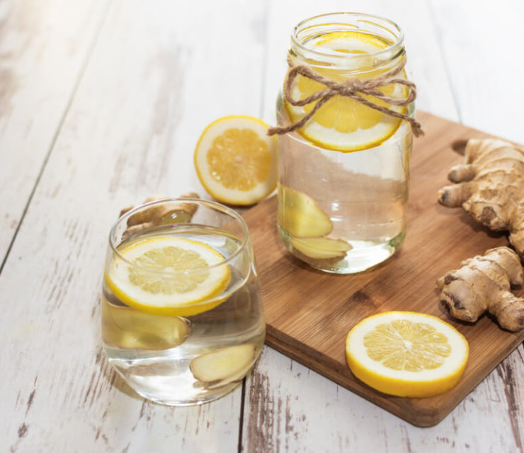 Ginger with lemon detox water in the morning on wooden background.