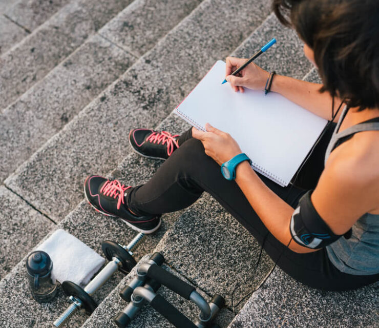 woman writing down fitness goals
