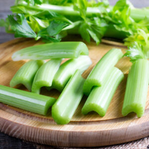 Fresh celery stems on wooden cutting board