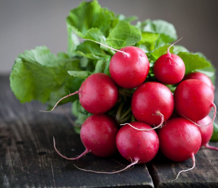 Fresh radishes on old wooden table