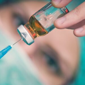 Doctor holding syringe and preparing for vaccine.