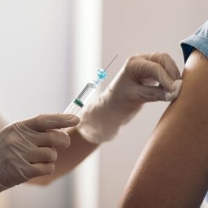 doctor cleaning arm with cotton before vaccination