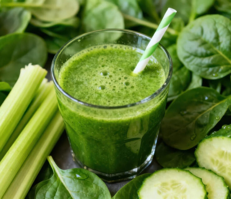 Of a refreshing green smoothie, accompanied by fresh spinach, celery, and cucumber, showcasing a healthy and nutritious lifestyle.