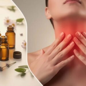 Conceptual wellness and medical editorial image about thyroid health and essential oils. Split composition with a curved or diagonal divider. Left side: group of small amber essential oil bottles with open tops, arranged naturally with flowers or herbs, soft natural lighting, warm tones, clean and minimal styling. Bottles are unbranded with no readable labels. Right side: close-up of a person’s neck and throat area, hands gently touching the thyroid region. Subtle red or warm glow overlay on the neck to suggest discomfort or thyroid awareness.