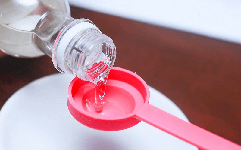 Pouring liquid coconut oil in spoon