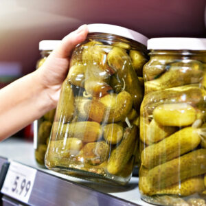 Canned pickles in hands in store