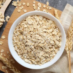 Composition with oatmeal flakes on gray background. Cooking breakfast