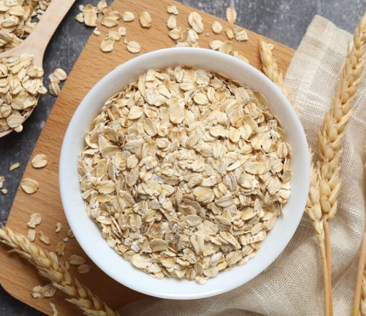 Composition with oatmeal flakes on gray background. Cooking breakfast