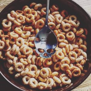 bowl of cheerios with skull-engraved spoon resting on top