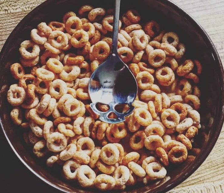 bowl of cheerios with skull-engraved spoon resting on top