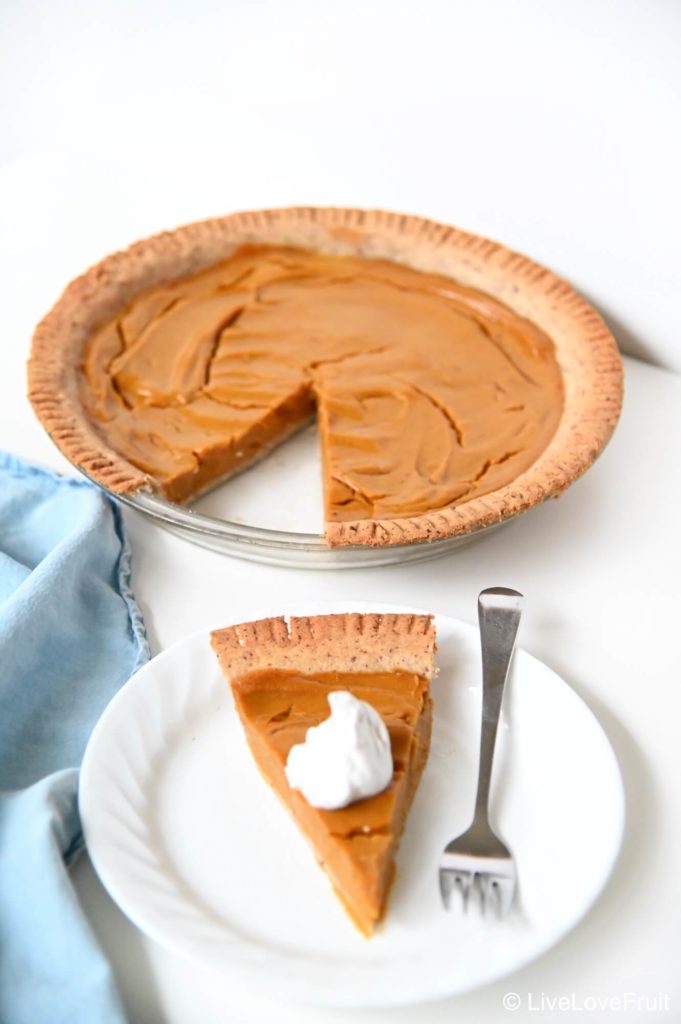 slice of pumpkin pie on plate with main pie dish in background