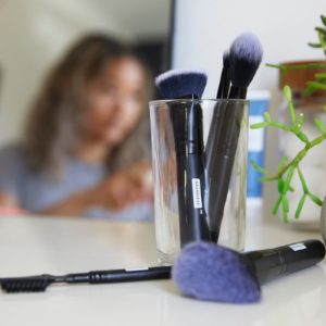 makeup brushes on desk with girl in background