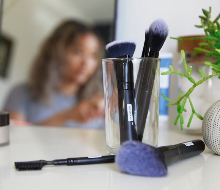 makeup brushes on desk with girl in background