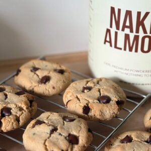 naked almond protein in background with chocolate chip cookies in foreground